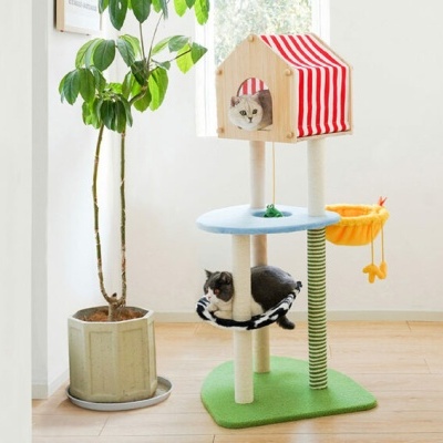 Arranhador para gatos com base verde, casa de madeira com tecto às riscas vermelhas e brancas, dois gatos