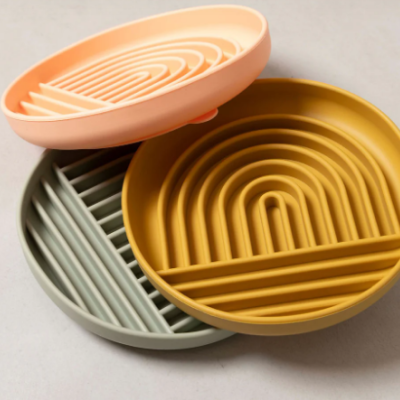 Três bases redondas de silicone para copos com padrão geométrico em três cores diferentes.