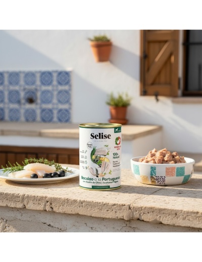 Lata de comida para cães Selise com bacalhau e dois pratos com alimento, fora de casa com parede branca e azulejos.