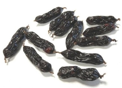 Vários figos da índia secos pretos sobre superfície branca