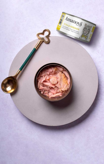 Lata aberta de atum e camarão Amanova com colher dourada e lata fechada ao lado, sobre fundo branco.