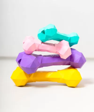 Halteres coloridos empilhados sobre superfície branca