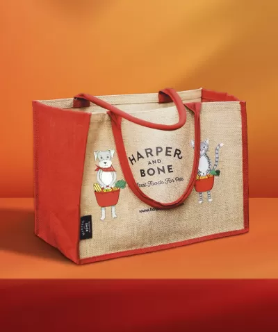 Saco de lona vermelho e bege com ilustração de cão e gato e texto HARPER AND BONE.