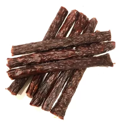 Tiras de carne seca castanha escura enrugada sobre fundo branco