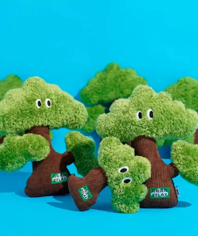 Peluches em forma de árvores verdes com olhos e etiqueta RELAX