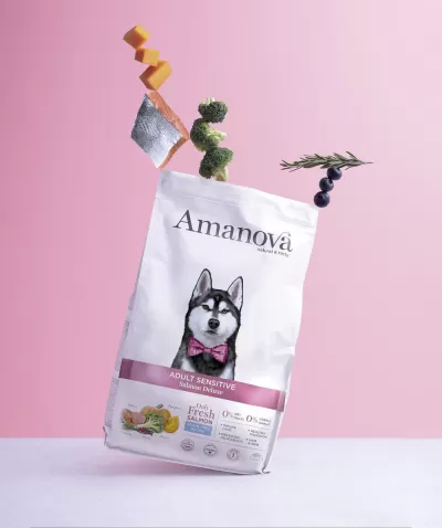 Embalagem de ração para cães Amanova Adult Sensitive sabor Salmão e Batata doce com cão Husky na frente em fundo rosa