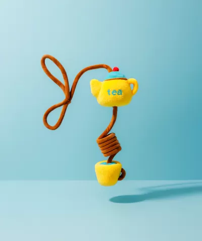 Brinquedo pendurado em forma de bule de chá e chávena de tecido amarelo