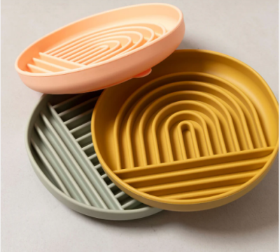 Três bases redondas de silicone para copos com padrão geométrico em três cores diferentes.