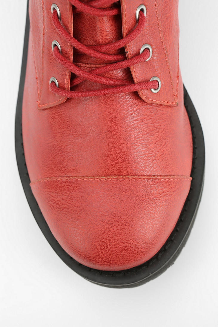 Bota vermelha de couro com cadarços e sola preta vista de cima
