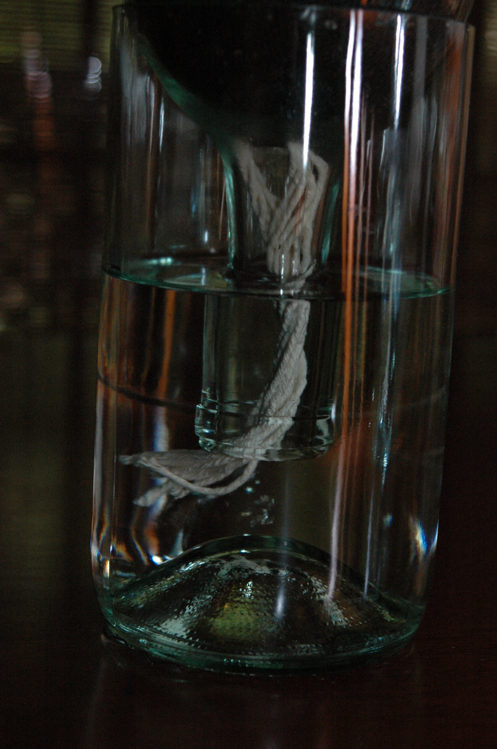 Frasco de vidro com líquido e corda branca imersa