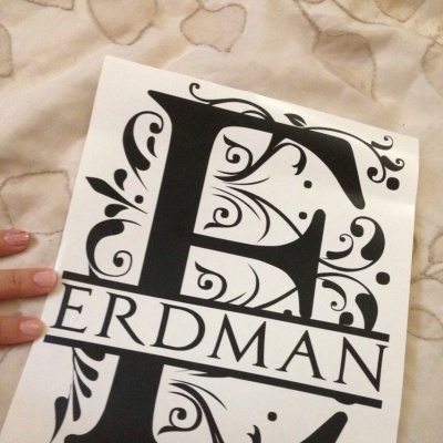 Folha branca com letra decorativa 'E' e texto 'ERDMAN' em fundo bege acolchoado.