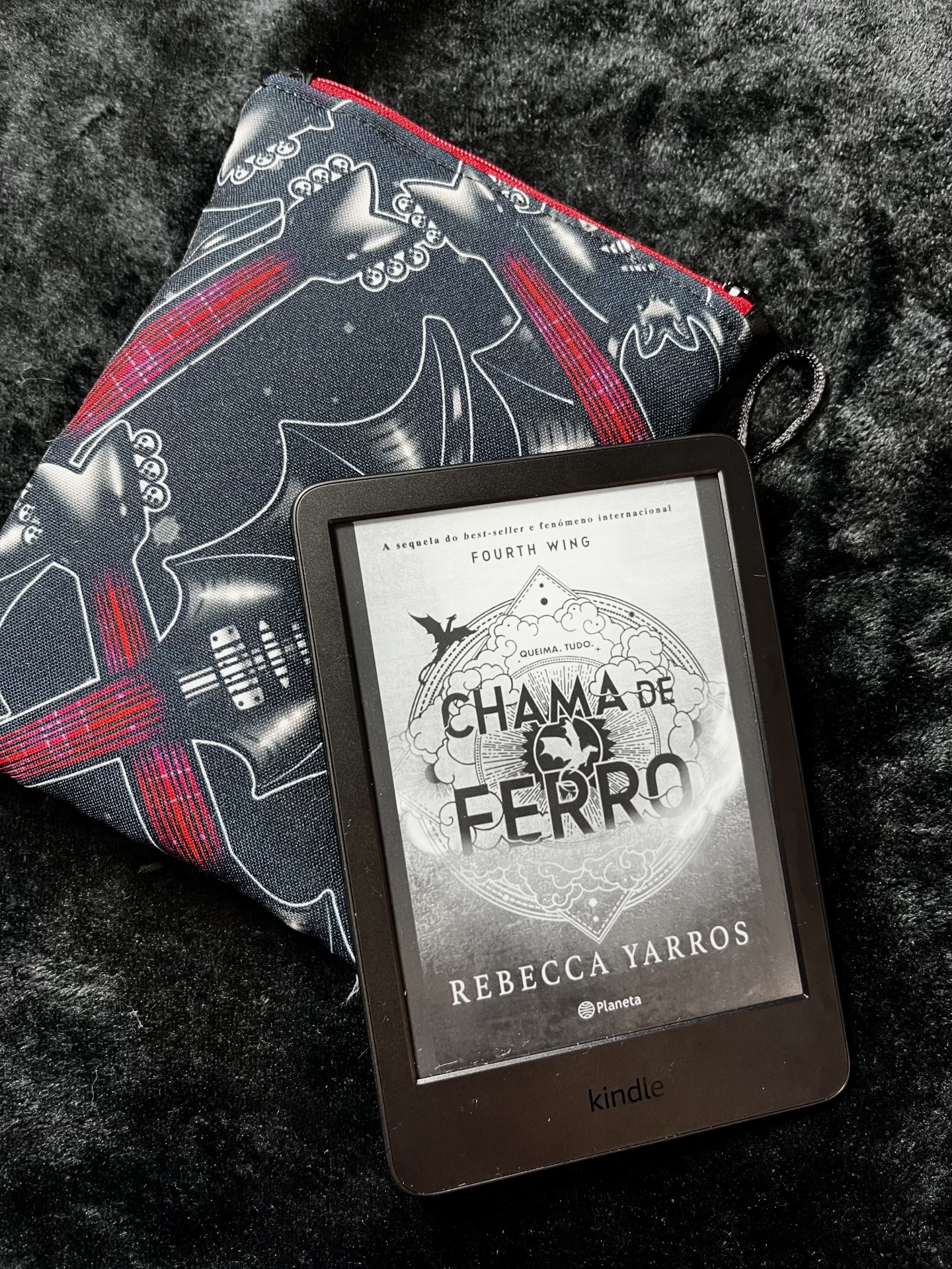 Bat Guitars E-Reader Kindle e-reader showing book cover, placed on guitar-patterned pouch and textured fabric.