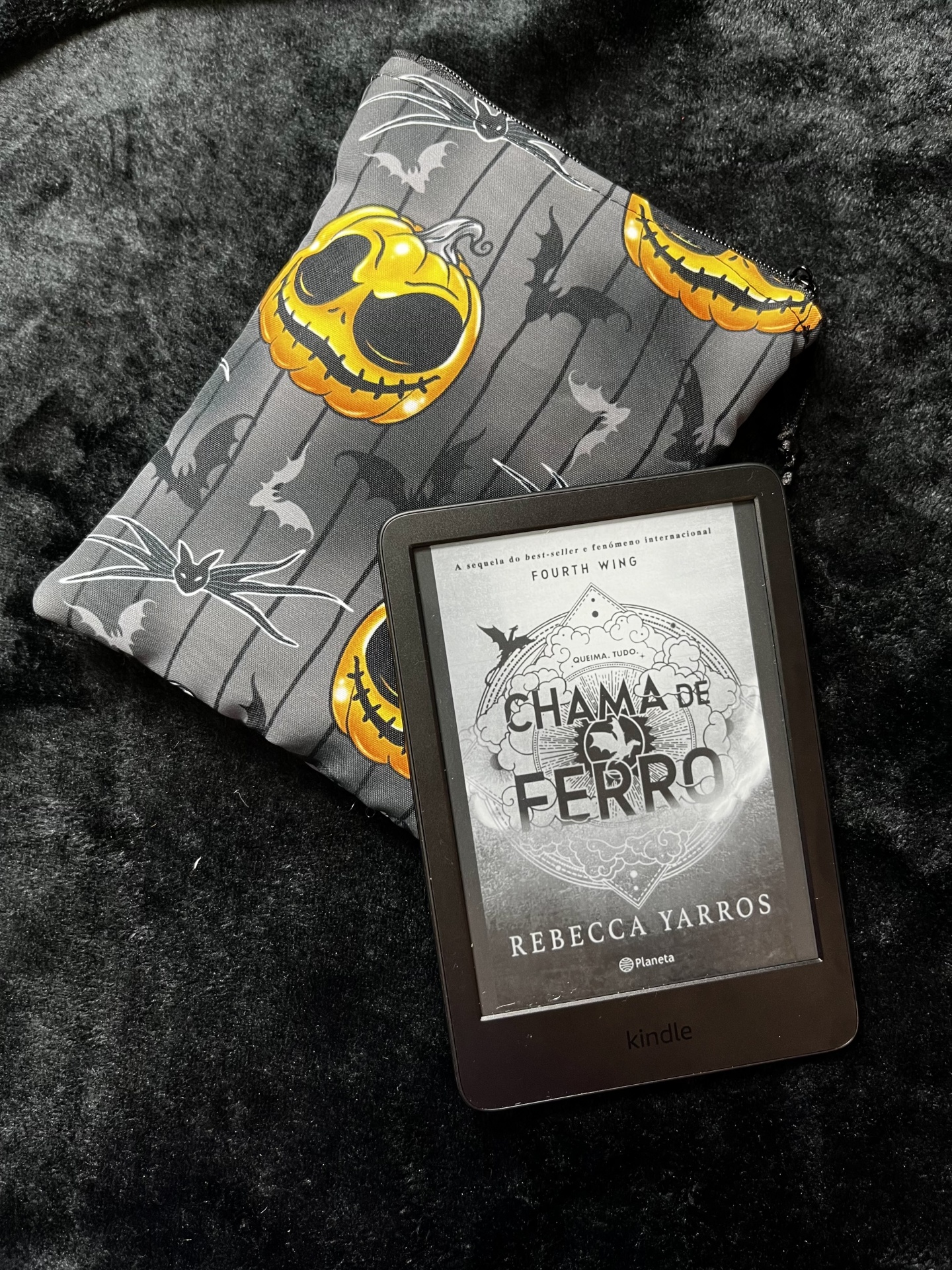 Pumpkin King E-Reader Kindle with book cover on fabric pouch with jack-o-lantern and bat design on black surface