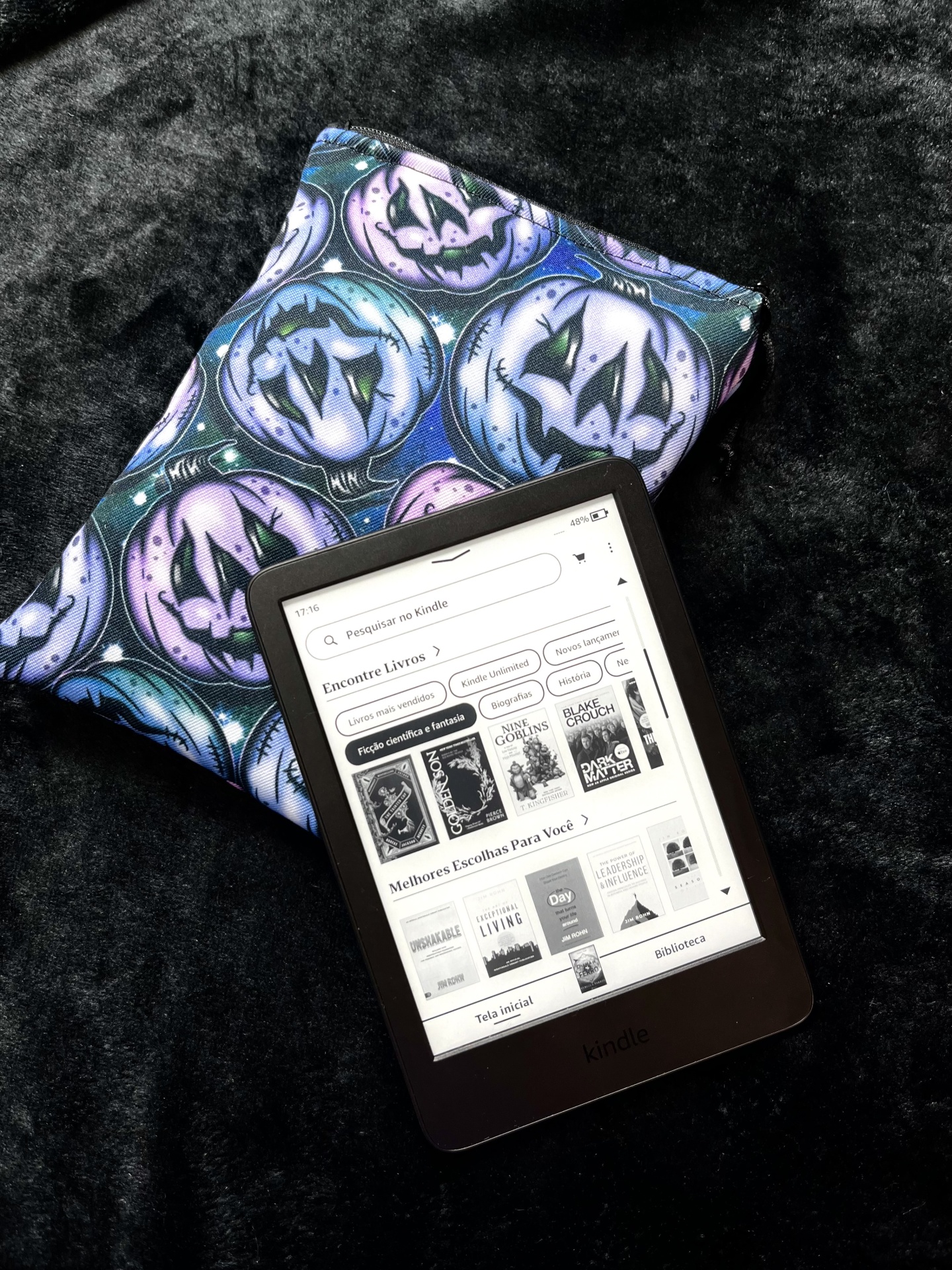 Pastel Pumpkins E-Reader Kindle e-reader and a fabric pouch with jack-o-lantern pattern on a black surface