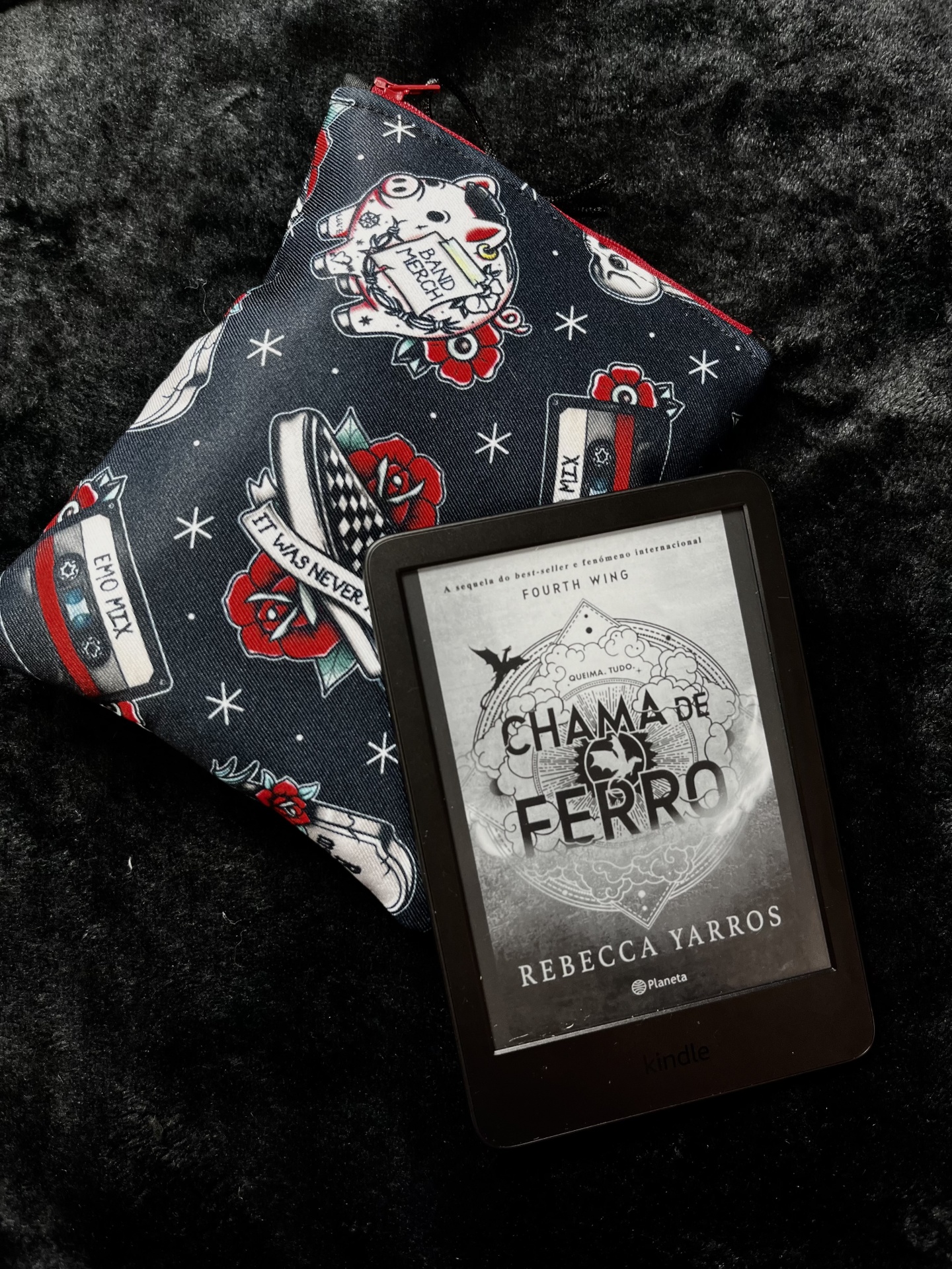 Elder Emo E-Reader Kindle e-reader displaying book cover Chama de Ferro by Rebecca Yarros next to a fabric pouch with dark blue background and colorful prints