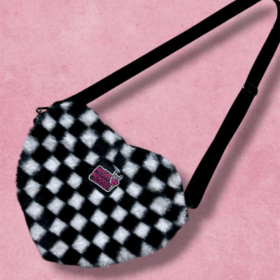 Black and white checkered fuzzy shoulder bag with MOSHPIT MEMORIES patch and black strap on pink background.