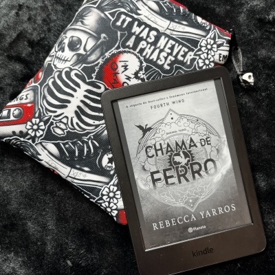 Kindle e-reader with book cover and a pouch with skeleton design and text