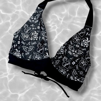 Black halter bikini top with white tattoo print on water background