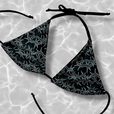 Black bikini top with white spiky pattern on water surface background