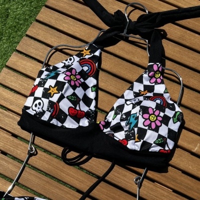 Checkered bikini top with colorful cartoon prints on wooden surface