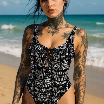 Woman wearing a black and white patterned swimsuit on a beach