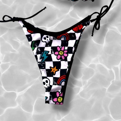 Checkered bikini bottom with colorful playful patterns and black side ties on water background