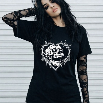 Black t-shirt with skull and barbed wire heart graphic worn over black lace sleeves with white panel wall background