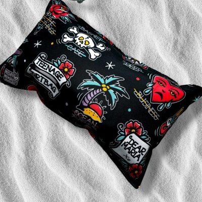 Black pouch with colorful tattoo-style prints and text on white textured background