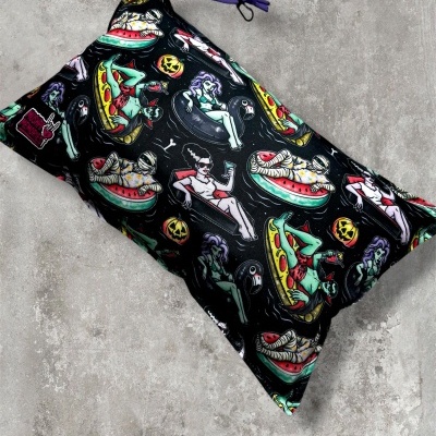 Black pouch with Halloween-themed spooky character print and purple drawstring