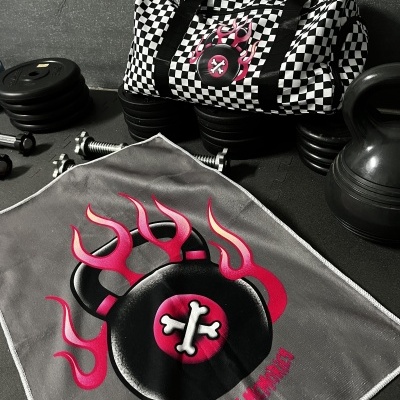 Checkered duffel bag with flaming kettlebell logo and gym weights