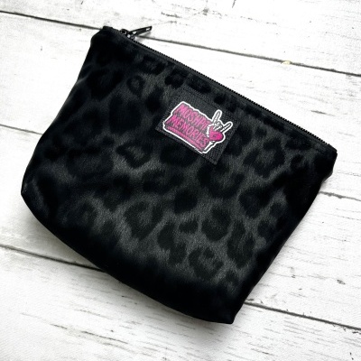 Black leopard print pouch with MOSHPIT MEMORIES patch on white wood