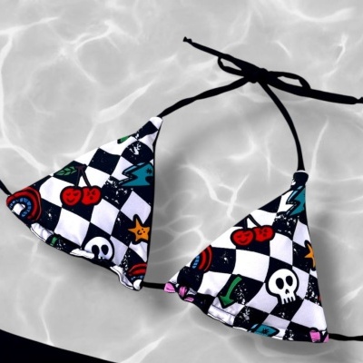Bikini top with checkerboard and colorful graphic icons floating on water.