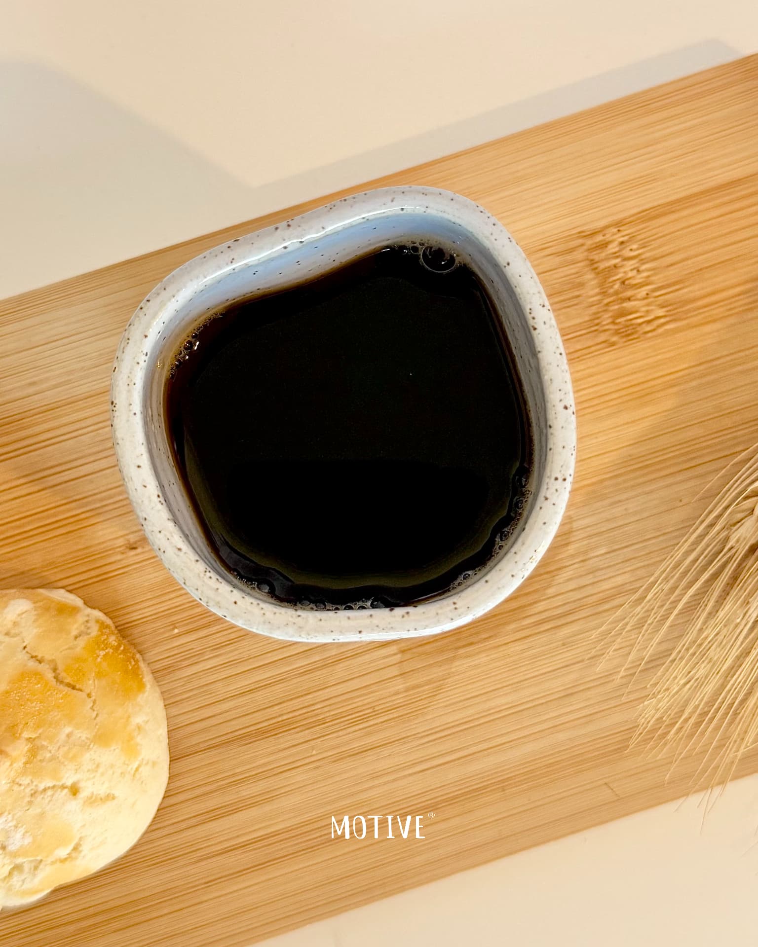 Copinho de Café CALMA CARALHO - Azul Celeste Taça em cerâmica branca com líquido escuro sobre tabuleiro de madeira com pão e trigo