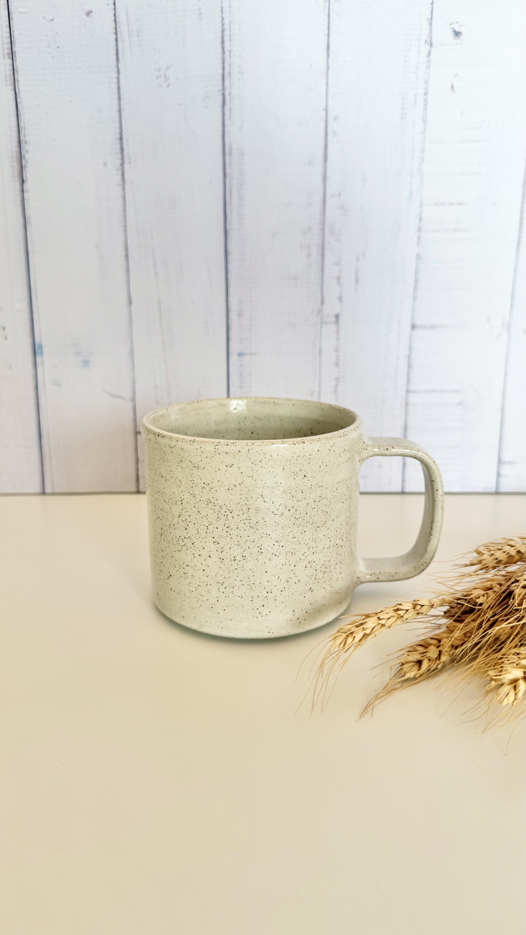 Caneca Foda-se, pá - Branco Vintage Caneca bege claro com manchas sobre superfície clara e espigas de trigo ao lado