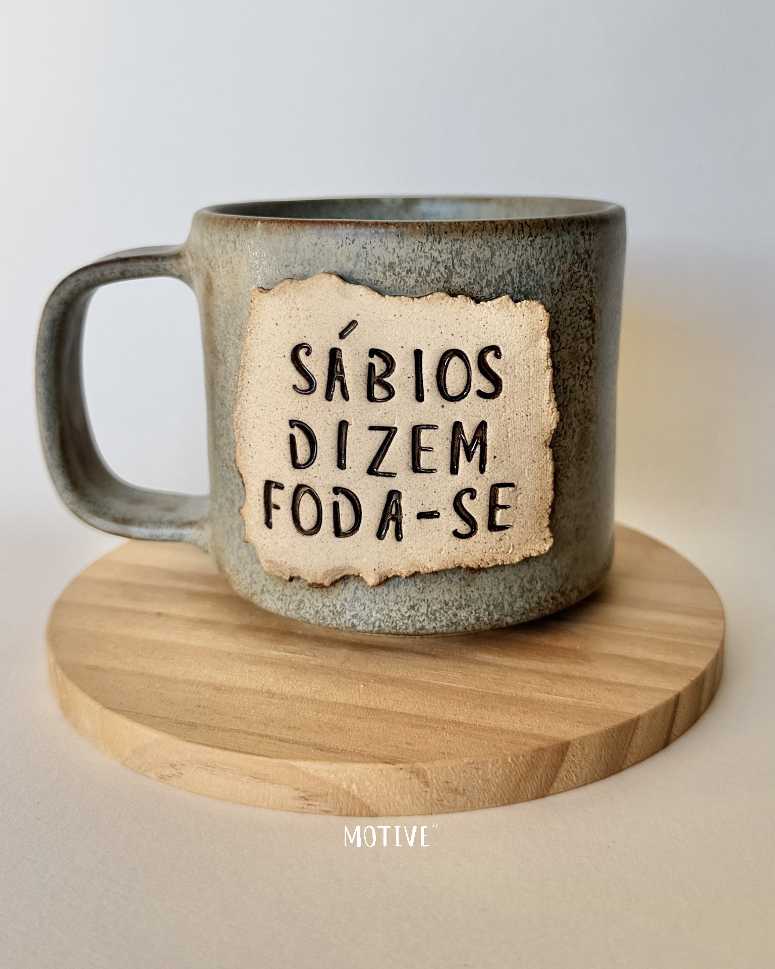 Caneca Sábios Dizem Foda-se Caneca de cerâmica cinza com placa bege e texto em relevo