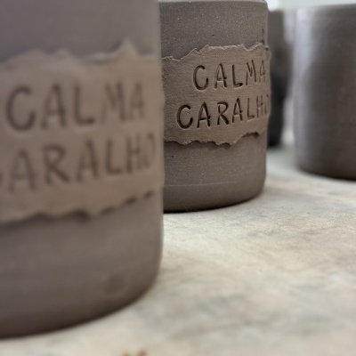 Vasos de cerâmica cinzenta com etiqueta CALMA CARALHO