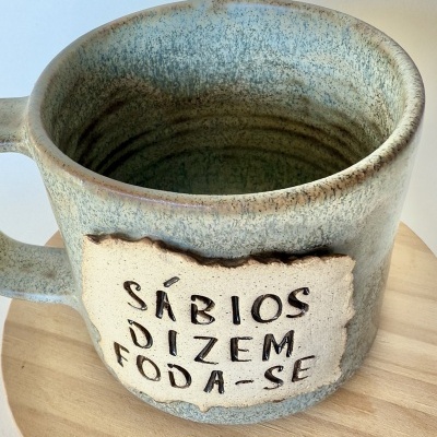 Caneca cerâmica verde e bege com texto em relevo