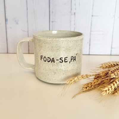 Caneca de cerâmica bege com frase FODA-SE, PÁ e trigo ao lado