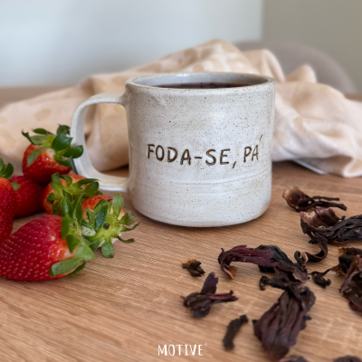 Caneca cerâmica branca com texto FODA-SE, PÁ com morangos e flores secas em madeira