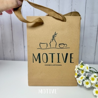 Saco de papel castanho com impressão preta e flores ao lado