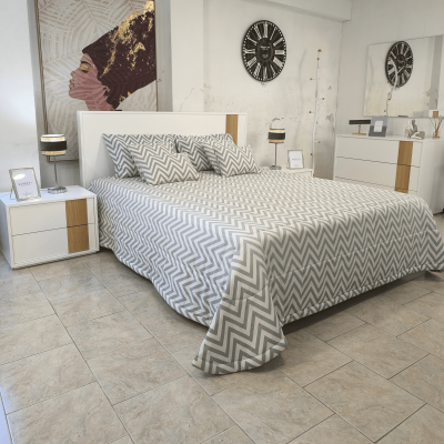 Quarto com cama de casal com roupa de cama cinza e branca, mesas de cabeceira brancas e relógio de parede preto