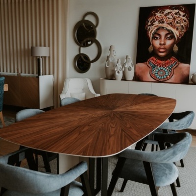 sala de jantar moderna com mesa de madeira e cadeiras cinza, quadro de mulher africana na parede branca