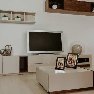 Sala de estar com móvel de TV e prateleiras de madeira com decoração