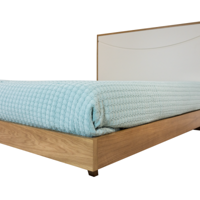 Cama de madeira com cabeceira branca e manta azul clara texturizada