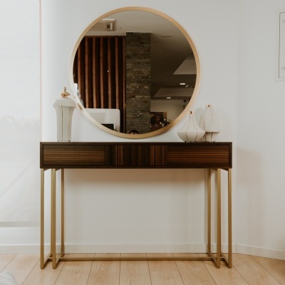 Consola de madeira escura com espelho redondo e decoração moderna