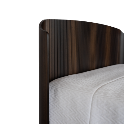 Cabeceira de cama em madeira escura com cama de colcha branca