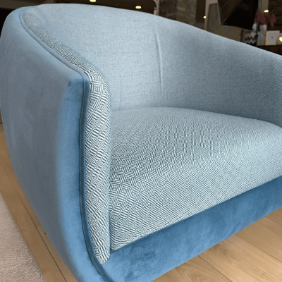 Sofá azul com assento padrão geométrico cinza e branco