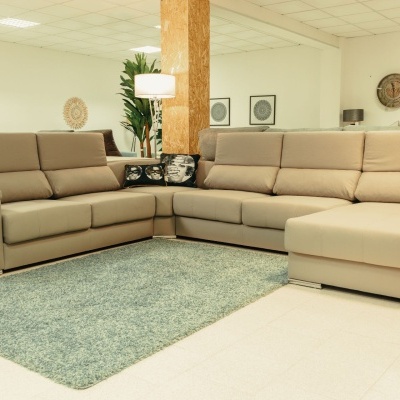 Sofá de canto em pele sintética bege numa sala de exposição