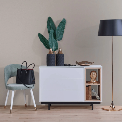 Aparador branco com gavetas e prateleiras, decorações, cadeira verde e candeeiro de pé