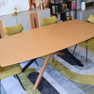 Mesa de jantar em madeira clara com cadeiras amarelas estofadas e tapete colorido